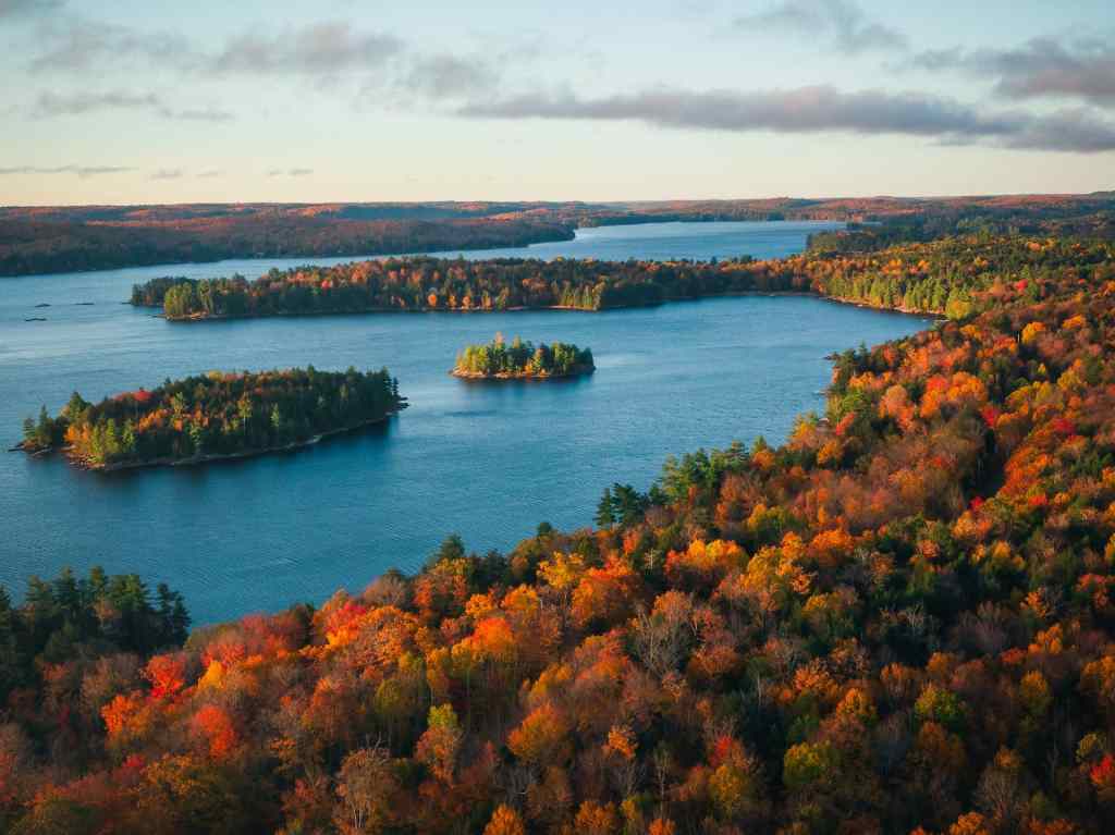 Canadian lake in autumn, surrounded by coloured trees